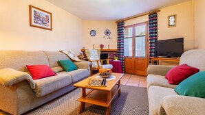 A living room with a sofa, armchairs, a coffee table, a television, and a fireplace. - Country House 'Casa Lino' with Mountain View, Private Terrace and Wi-Fi (Culla)