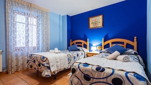 A room with two beds, a window with curtains, a wall painting, and a bedside lamp. - Country House 'Casa Lino' with Mountain View, Private Terrace and Wi-Fi (Culla)