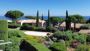 Una propiedad costera de arquitectura mediterránea, con piscina y vista al mar.