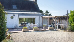 A house with a patio area, outdoor seating, and a gravel driveway. - Holiday Home 800 m From the Beach with Private Terrace and Private Garden (Penmarc'h)