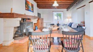 Un comedor con mesa de madera, sillas y chimenea.