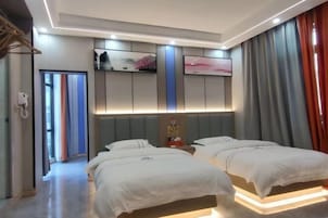 A hotel room with two beds, a flat-screen TV, a minibar, and a large window with curtains.