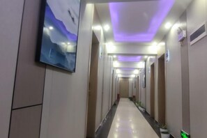 A hotel corridor with a long, straight path, multiple doors, and a flat ceiling with recessed lighting. - Jinyang Grain Trade Hotel (Jinyang)