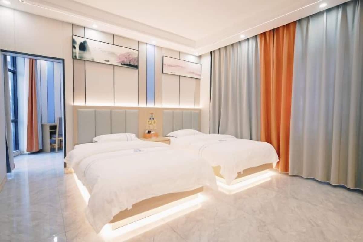 Ein modernes Hotelzimmer mit einem großen Bett, einem Nachttisch und einem an der Wand montierten Fernseher.