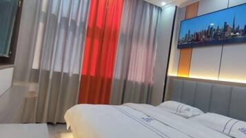 A hotel room with a bed, curtains, a cityscape painting, and a staircase.