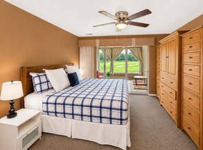 A bedroom with a bed, nightstand, dresser, and a ceiling fan. - Lounging on the Links (Branson)