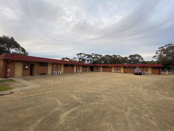 Un motel con varias habitaciones, unidades de aire acondicionado y un área de estacionamiento.