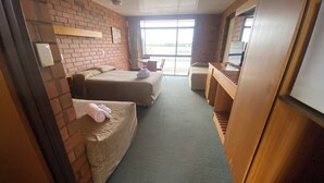 A room with two beds, a desk, a chair, and a television. - Hawker Hotel Motel (Hawker)