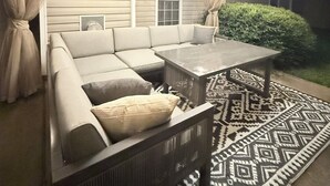 Eine Terrassengruppe mit Ecksofa, Couchtisch und Lichterkette.