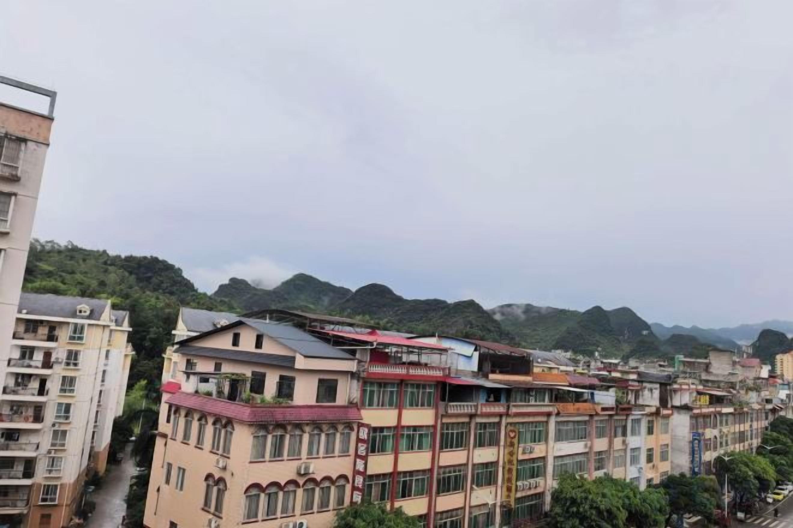 A multi-story building with a flat roof and a series of windows.