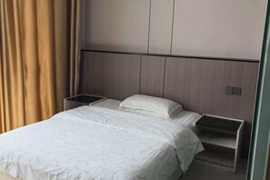 A hotel room with a bed, bedside tables, and a headboard. - Debao Hongshanyuan Hotel (Debao)