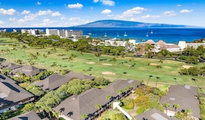 A golf course with a pool and a view of the ocean.