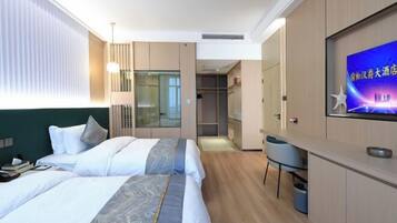 A hotel room with two beds, a TV, a desk, and a wardrobe.