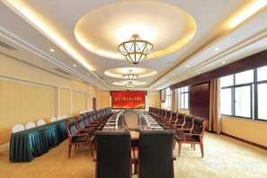 A conference room with a long table, chairs, and a large screen. - Hanjue Hotel (Susong)