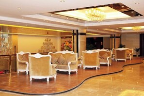 A lobby with a curved seating area, a bar with glasses, and a chandelier. - Hanjue Hotel (Susong)