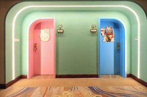 A hotel hallway with two doors, one pink and one blue, each with a unique character decoration. - Hanjue Hotel (Susong)