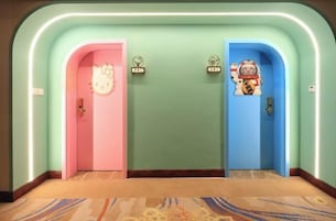 Un pasillo de hotel con dos puertas, una rosa y otra azul, cada una con una decoración distintiva.