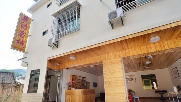 A building with a reception desk, wooden interior, and a signboard. - Yunshui Jingxiu Inn (Nanjing County)