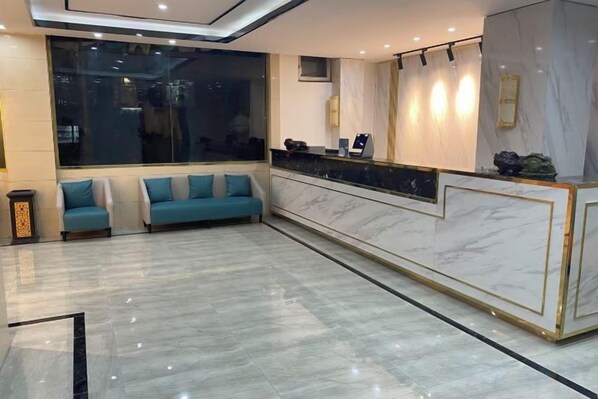 A hotel lobby with a reception desk, seating area, and a large window. - Ximucuo Hotel (Jigzhi)