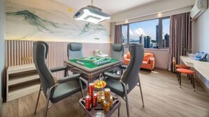 A hotel room with a pool table, gaming chairs, a city view, and a modern ceiling design. - Dongsheng Hotel（Puning International Commodity City · High-speed Rail Station Branch） (Puning)