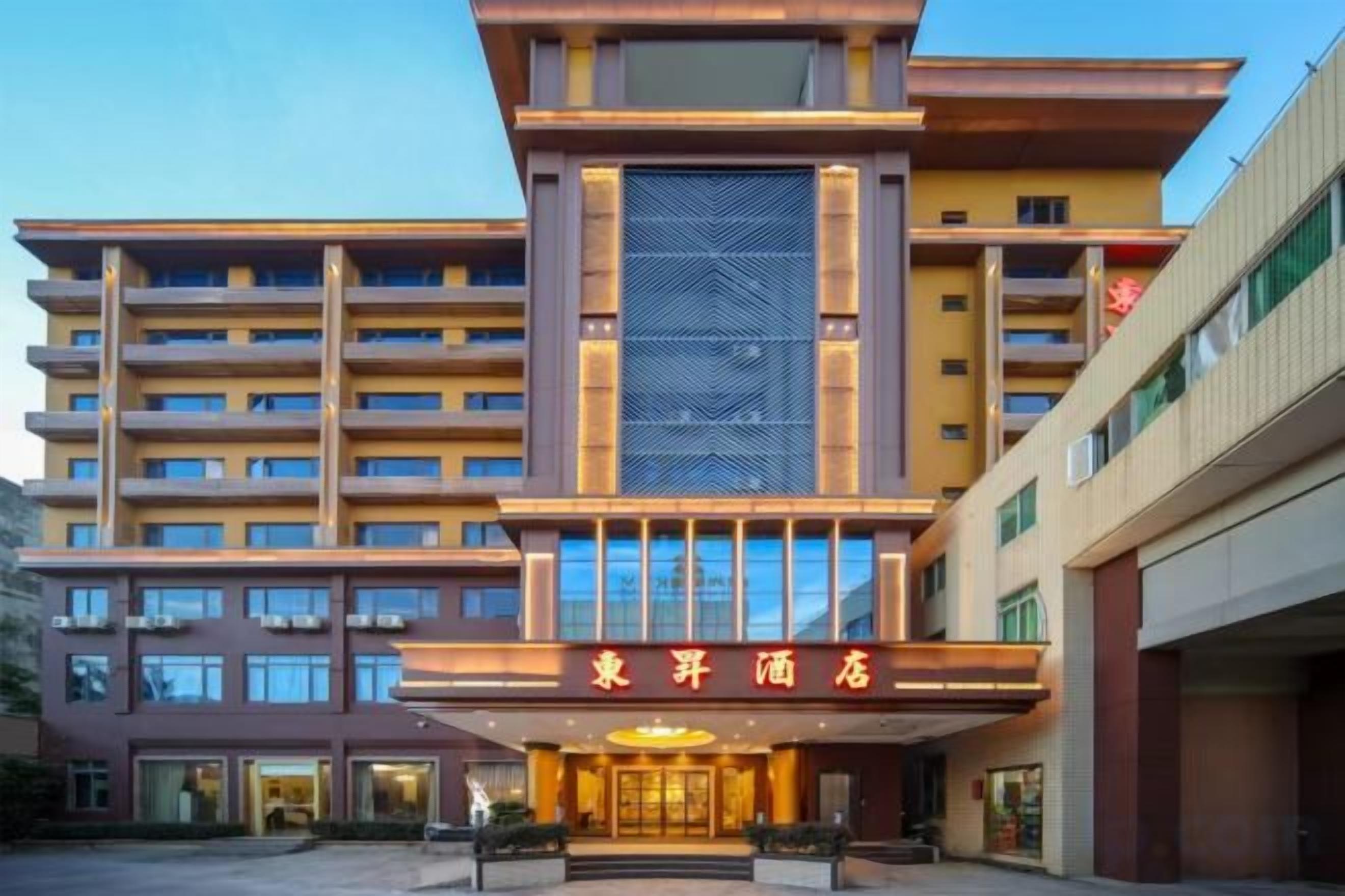 Ein mehrstöckiges Hotel mit einem markanten Eingang und einer großen Beschilderung über den Türen.