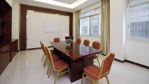 A conference room with a large rectangular table surrounded by six chairs, a whiteboard on the wall, and large windows with curtains. - Dongsheng Hotel（Puning International Commodity City · High-speed Rail Station Branch） (Puning)