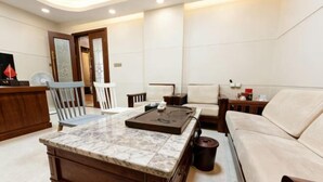A modern living room with a marble coffee table, a sofa, and a wooden cabinet. - Dongsheng Hotel（Puning International Commodity City · High-speed Rail Station Branch） (Puning)