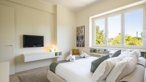 A modern bedroom with a large bed, a mounted TV, a painting, and a window with a city view. - Domus Consalvi (Ponte Milvio): large design apartment - 3 bedrooms (Roma)