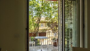 An open sliding glass door leading to an outdoor patio area with a round table and two chairs. - Domus Consalvi (Ponte Milvio): large design apartment - 3 bedrooms (Roma)