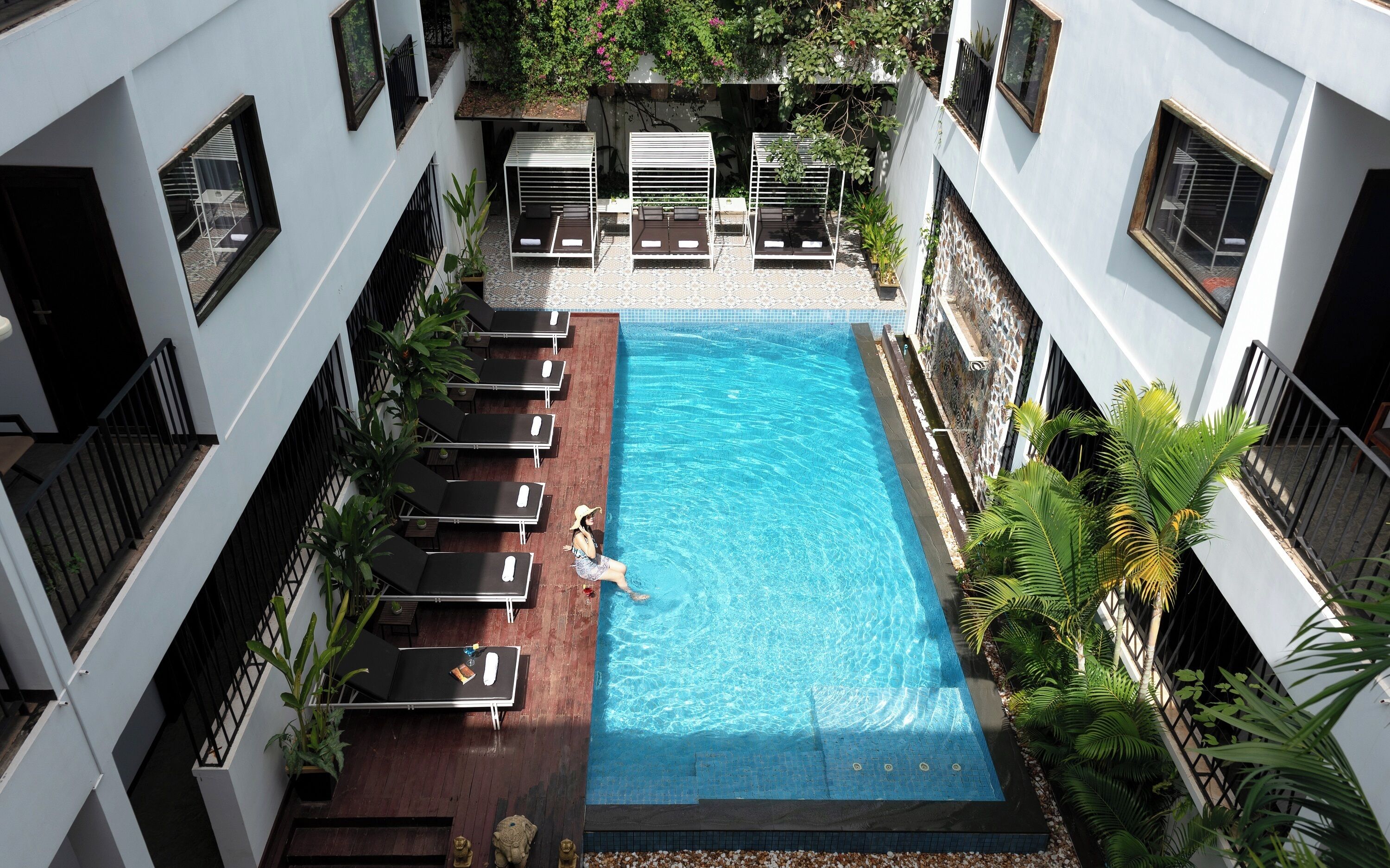 Una piscina al aire libre, camas de piscina gratis, sombrillas