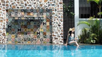 Una piscina al aire libre, camas de piscina gratis, sombrillas