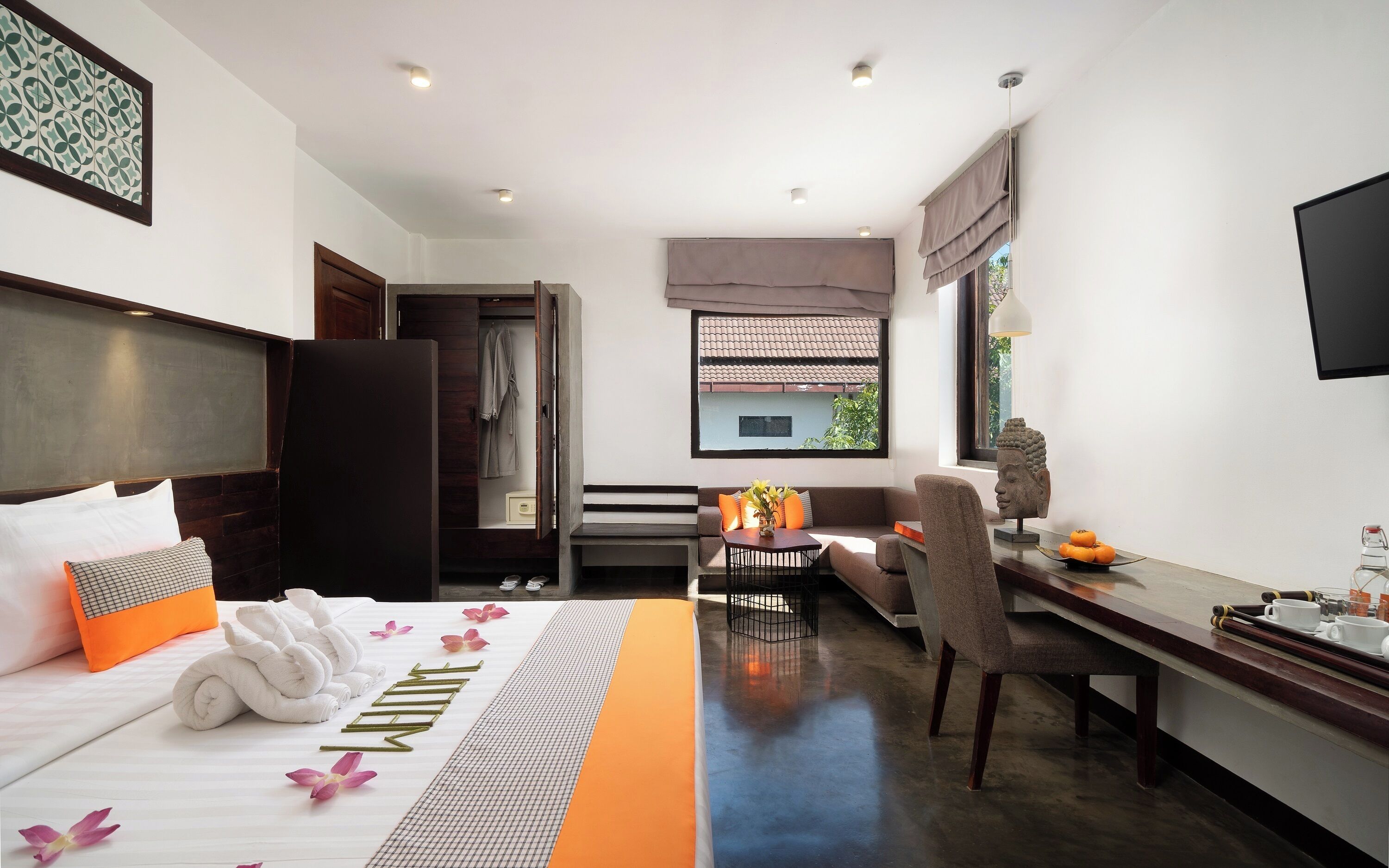 A hotel room with a bed, a desk, a chair, a window, and a view of the outside.