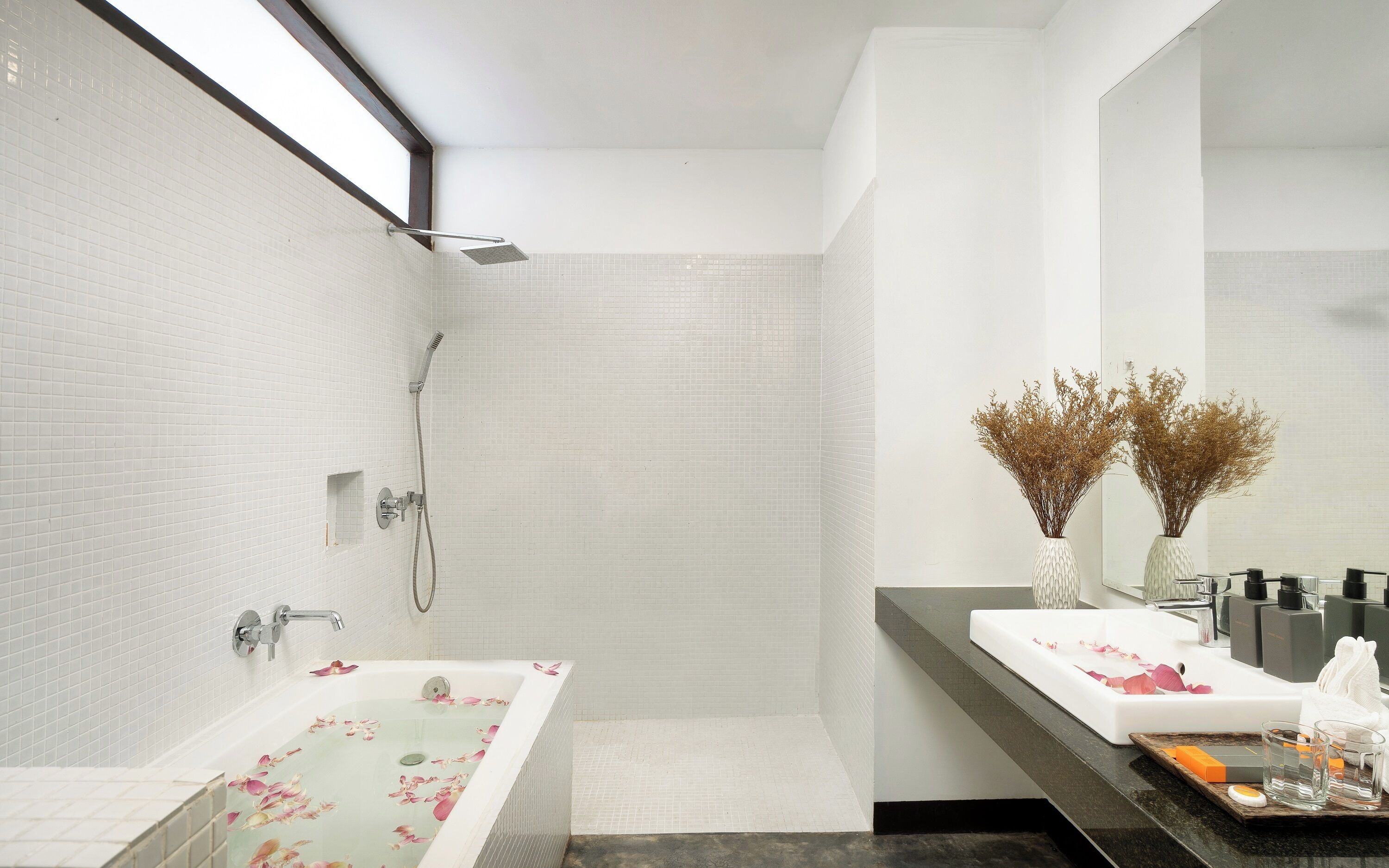 A modern bathroom with a walk-in shower, a freestanding bathtub, and a vanity with a mirror.