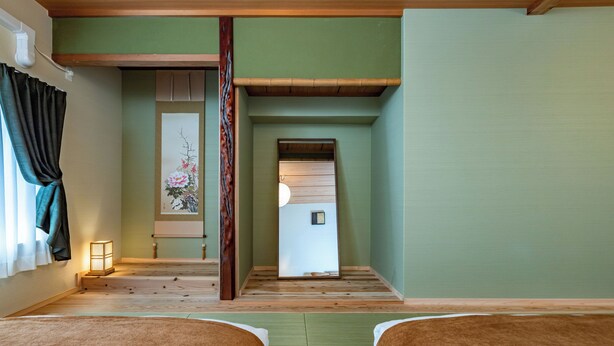 Una habitación tradicional japonesa con suelo de tatami, pantalla shoji y futón.