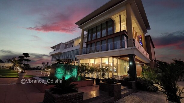 A modern hotel with a two-story structure, large windows, and a well-lit entrance. - Vbrance - Luxury Boutique Hotel (Puri)