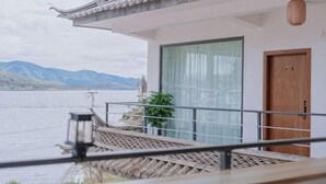 A traditional-style building with a balcony overlooking a body of water and mountains in the distance. - Shuanglang Ziyan Zhuangyuan Inn (Dali City)