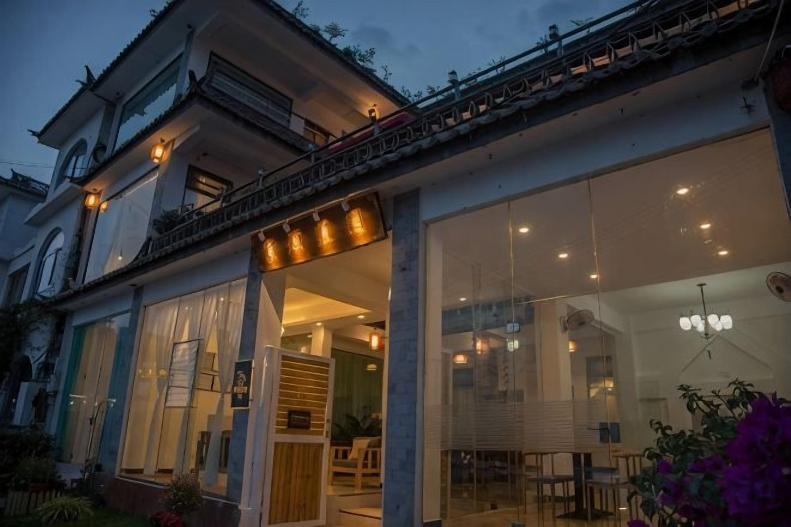 Un edificio de dos pisos con ventanas grandes y un balcón.