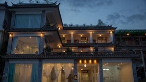 A traditional-style building with multiple levels, large windows, and a balcony. - Shuanglang Ziyan Zhuangyuan Inn (Dali City)