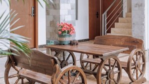 A wooden table with chairs, a flower vase, and a staircase in the background. - Shuanglang Ziyan Zhuangyuan Inn (Dali City)