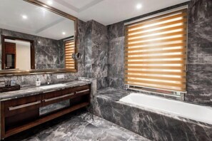 A bathroom with a marble vanity, a large mirror, a bathtub, and wooden blinds. - Hengrong Holiday Hotel (Chongqing)