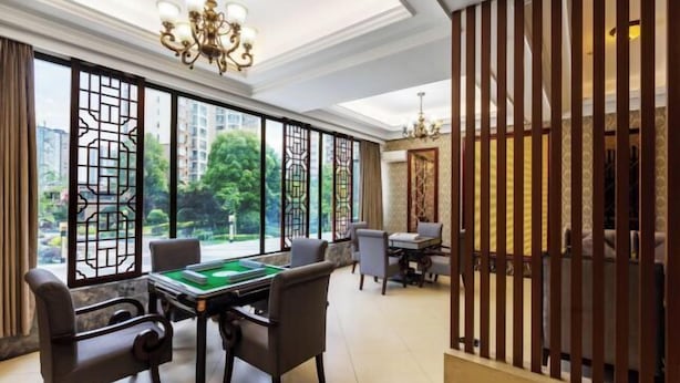 A room with a pool table, comfortable seating, and large windows offering a view of greenery and buildings. - Hengrong Holiday Hotel (Chongqing)