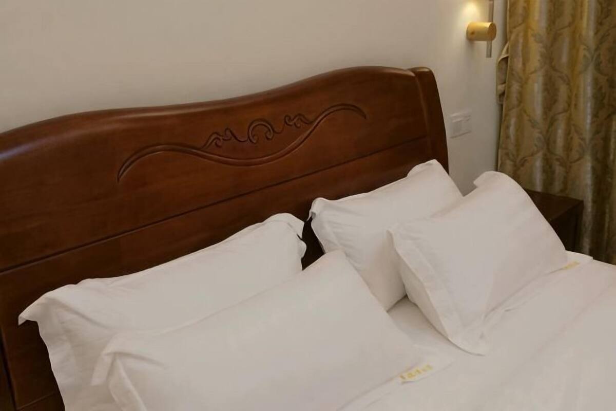 A bed with a wooden headboard and white bedding.