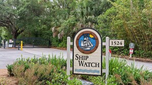 A sign with the text "Ship Watch" and the number "1524" in a natural setting with greenery.
