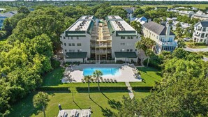 A multi-story hotel with a central courtyard and a swimming pool.