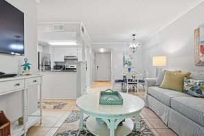 A compact living space with a kitchenette, a dining area, and a seating area with a sofa and chairs.