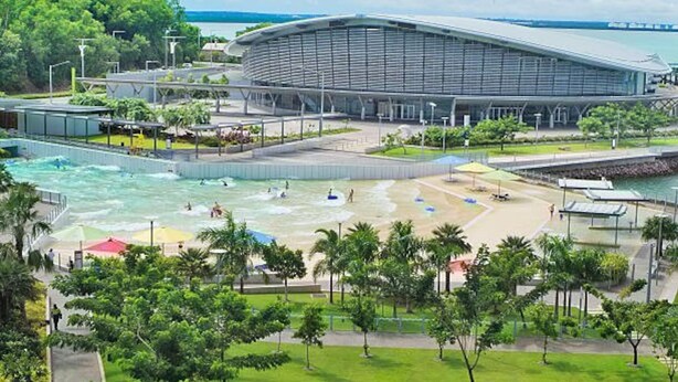 A modern building with a curved roof, surrounded by a water park area with slides and a pool. - Skytower Wonder Oceanview Balcony - Pool - Office (Darwin)