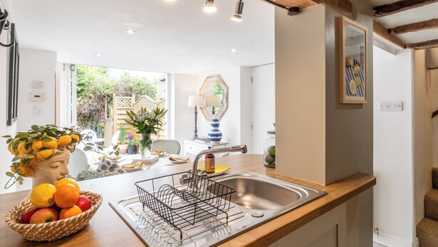 A kitchen with a wooden countertop, a sink, and a hanging light fixture. - Clifford Chambers Cosy 2 Bedroom Cottage (Stratford-upon-Avon)