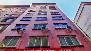 A multi-story building with a red facade and multiple windows. A sign on the building reads "PASHUPATI HOTEL (P.LTD.) Sundhara, Kathmandu Ph No. 01. 4216988, 4216999." - Pashupati Hotel  (Kathmandu)