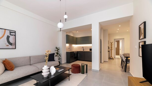 Un salon moderne avec un canapé, une table basse et un coin repas comprenant des chaises et une table.
