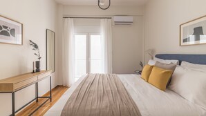 Une chambre à coucher comprenant un lit, une table de chevet, un miroir et un appareil de climatisation.